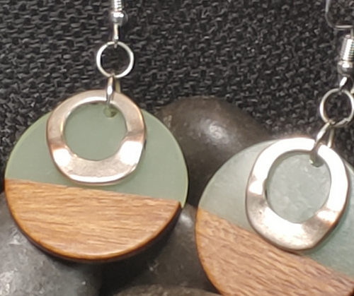 handmade Aromatherapy earrings. Circle shape. Top have light green acrylic. Lower have wood. smaller Silver colored floating circular embellishment layered on top.